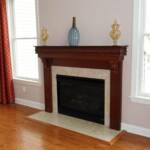 This Cherry fireplace and mantle features fluted columns and hand carved corbels surrounding an already existing marble fireplace.