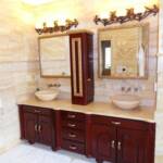 This Cherry bathroom vanity is finished with our Merlot toner.  It features full extension drawers, hand carved raised panel doors, and mirrors in a gold leaf frame.