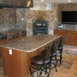 This cherry kitchen is finished with our light honey maple stain.  It features raised panel doors, fluted columns, granite countertops, a large island, stainless steel appliances, an imported pizza oven from Italy, and matching metal countertop height stools.
