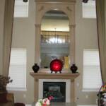 This marble fireplace is sprayed with our taupe lacquer and hand brushed with our antique Vandyke brown glaze.  It features fluted columns, hand carved corbels, a hand carved fireplace mantle, and a hand carved crown molding. A 10' mirror set in a fluted column and arch frame, with hand carved moldi