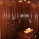 This Cherry custom closet features large 8' raised panel doors detailed with rope moldings.  All of the drawers are velvet lined and have full extension soft-close slides.
